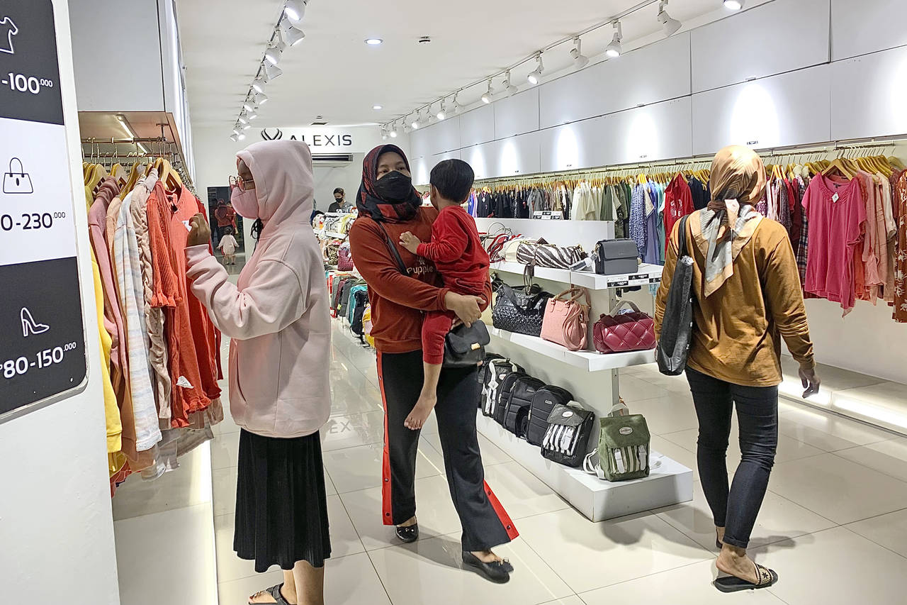 People wearing face mask browse for clothings at a shopping mall in Jakarta, Indonesia, Friday, Dec...